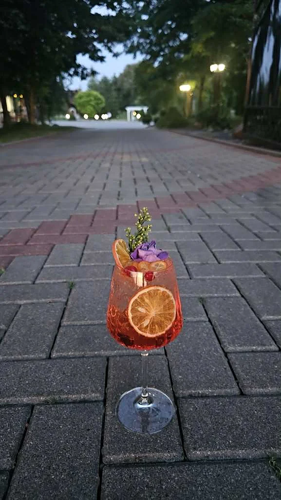 Spritz kokteilis vakare parko alėjoje
